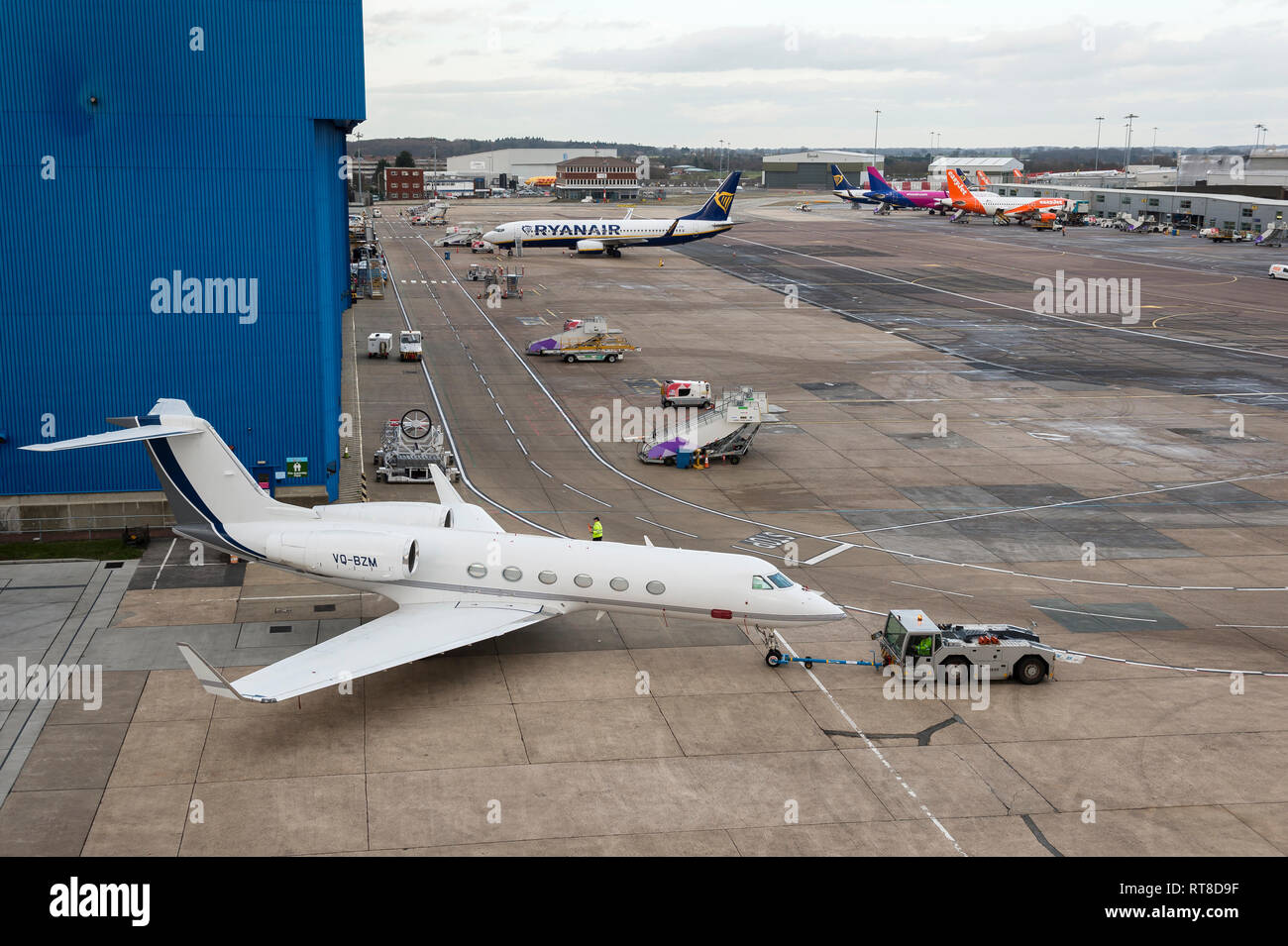Business jet being manoeuvred by a tug at Luton airport, England. Stock Photo