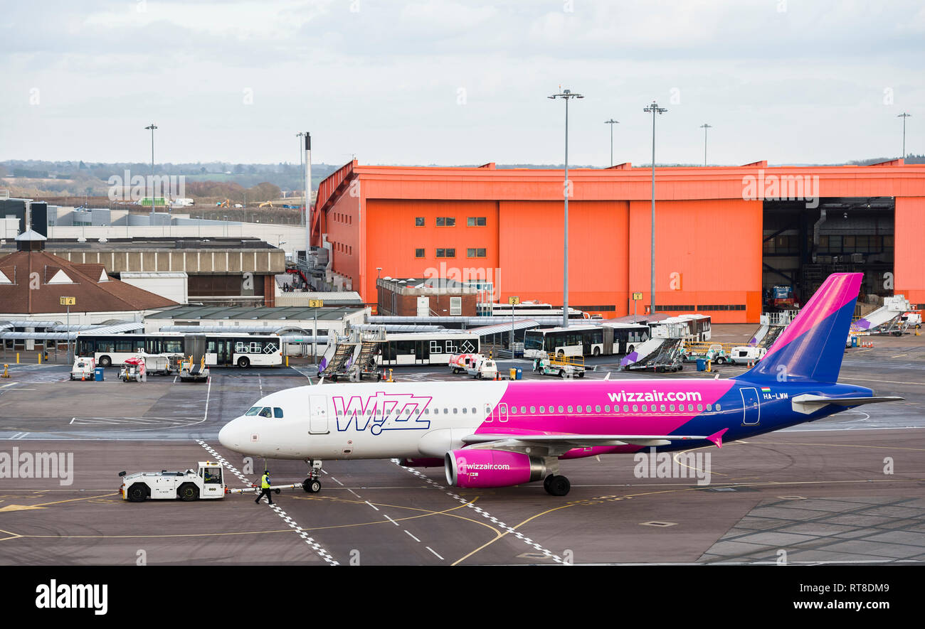 Wizz Air aeroplane being towed with a tug at Luton airport, England. Stock Photo
