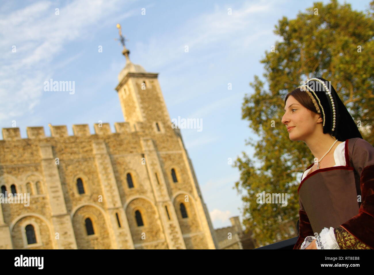 A woman dressed as Anne Boleyn stands in front of the Tower of London ...