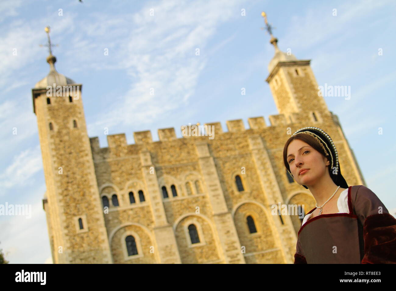 A woman dressed as Anne Boleyn stands in front of the Tower of London ...