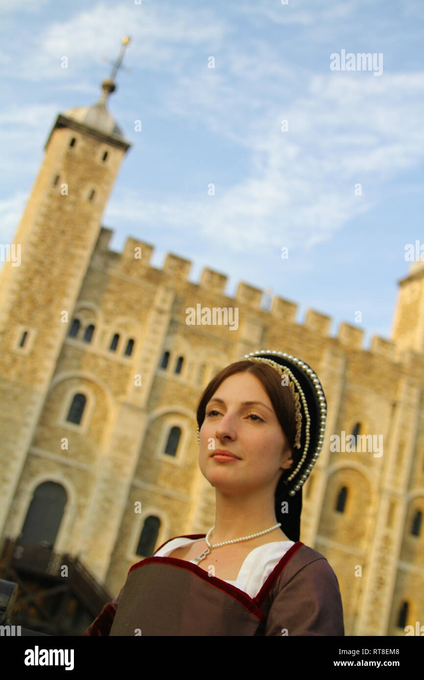 A woman dressed as Anne Boleyn stands in front of the Tower of London ...