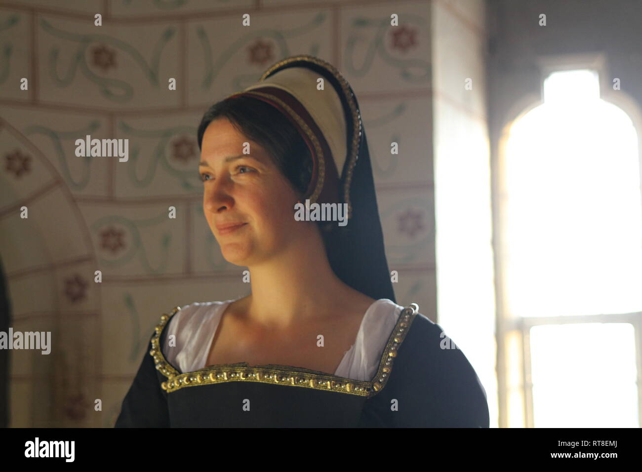 A beautiful but sad dark haired Tudor Woman in authentic Tudor dress looks in to camera- she is lady in waiting to Anne Boleyn Stock Photo
