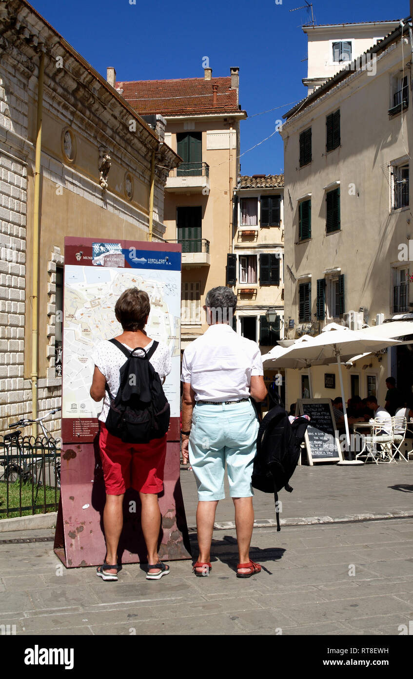 Tourist couple consult strret map in back streets and alley ways of old Corfu Town, Kerkyra, Greece Stock Photo