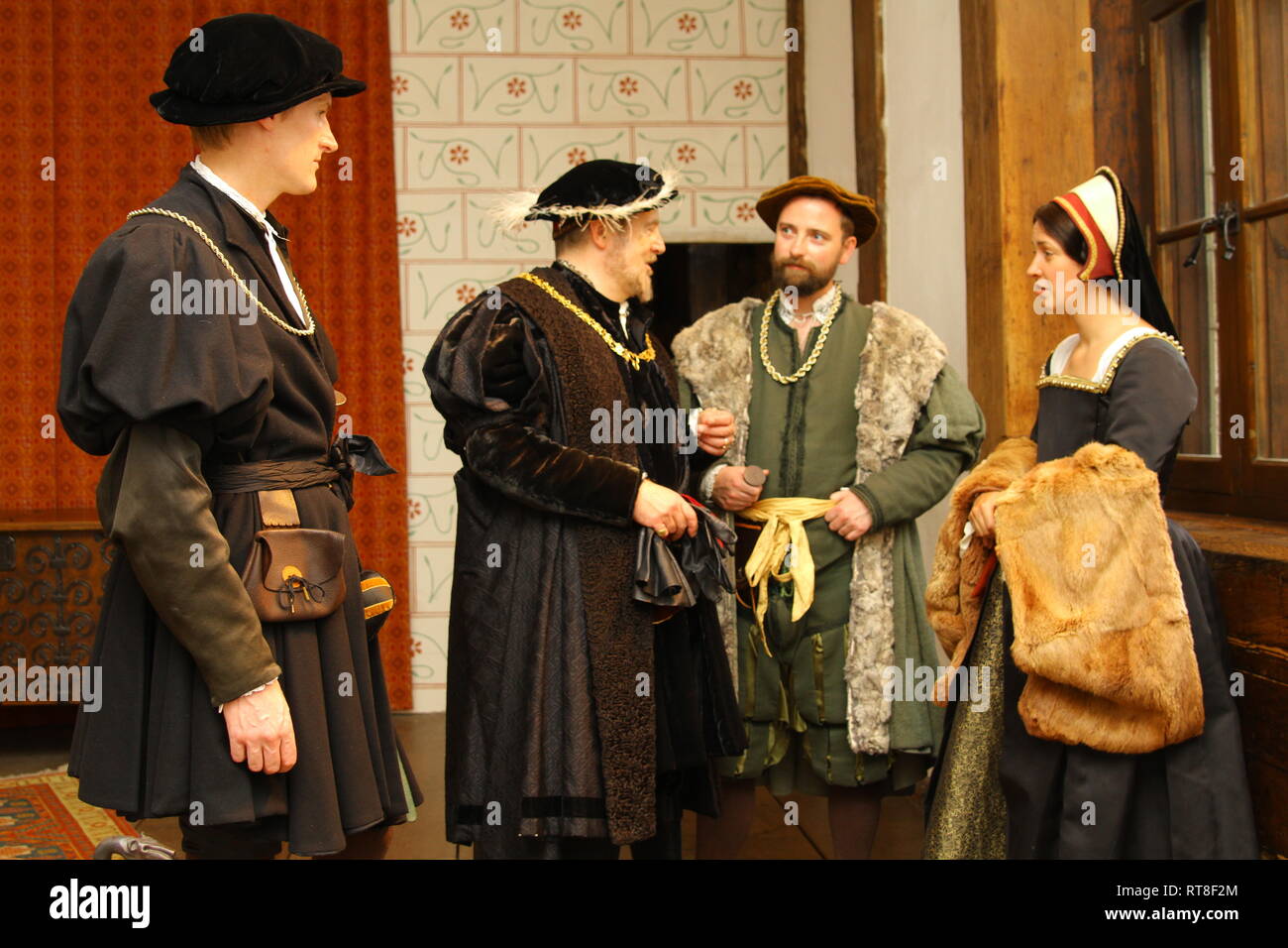 Henry VIII, his advisors and a Tudor woman chat inside The Tower of London- they are happy and wear authentic clothes Stock Photo