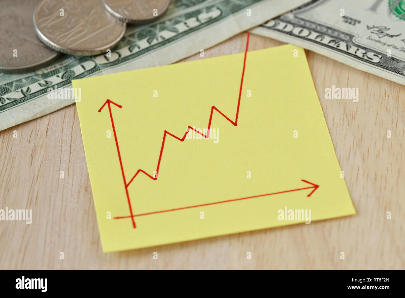Graphic with ascending line on paper note, dollar coins and banknotes ...