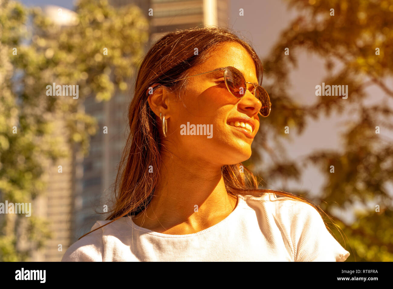Portrait of a beautiful smiling young woman in a white shirt and ...