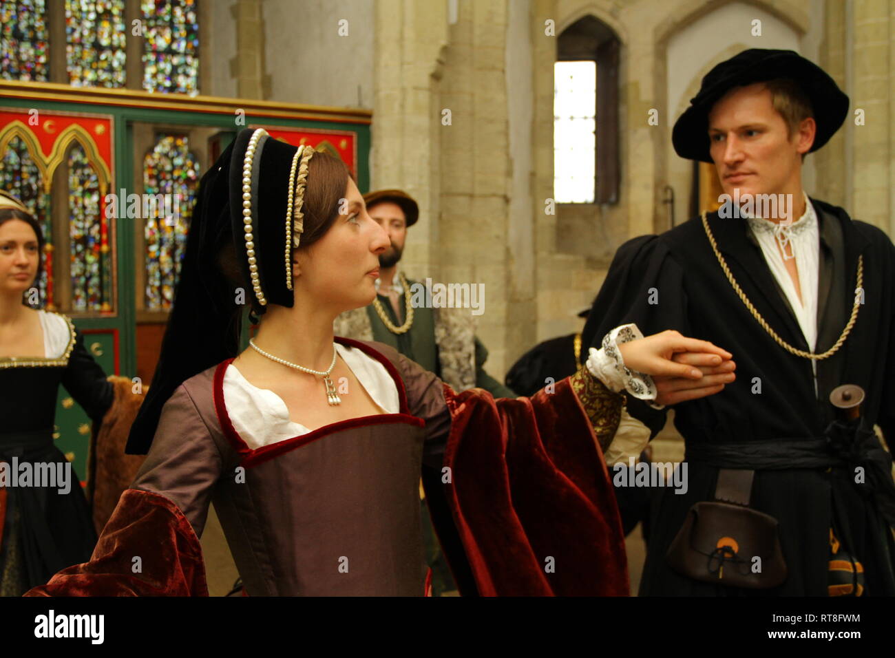 Anne Boleyn and Tudor friends dance together at The Tower of London- they are dressed in fine clothes Stock Photo