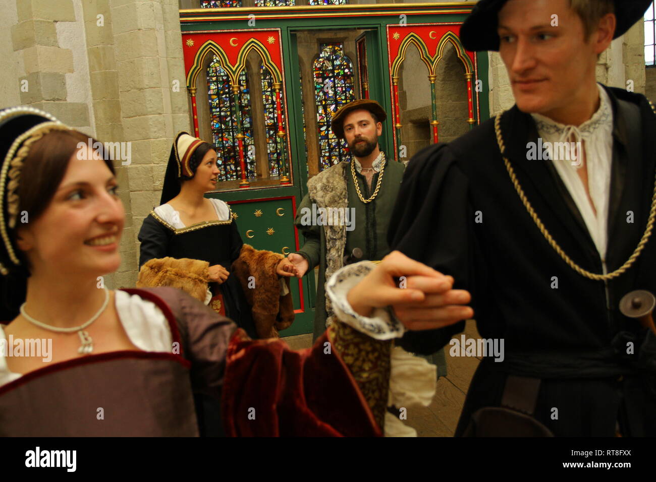 Anne Boleyn and Tudor friends dance together at The Tower of London- they are dressed in fine clothes Stock Photo