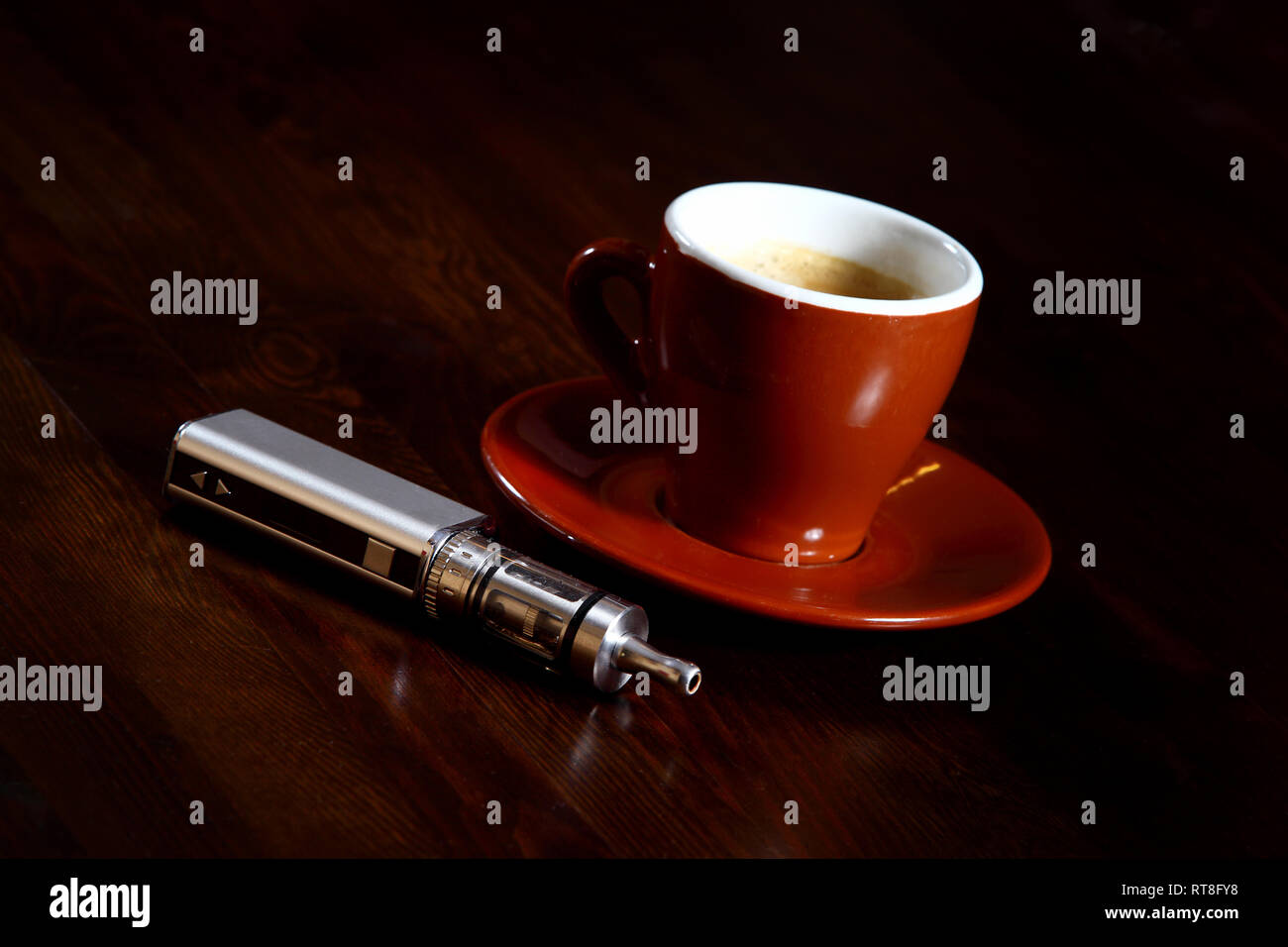 coffee e cigarettes e-Cigarette next to a cup of coffee. Expression of (modern) enjoyment and  relaxation Stock Photo