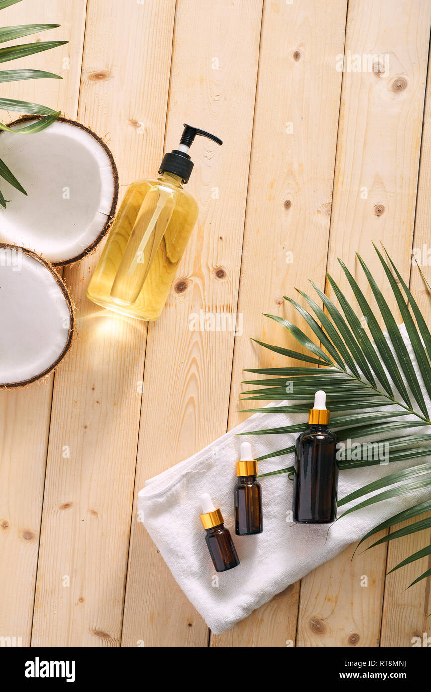 Cracked coconut and a bottle of oil on the table - spa, skincare, haircare and relaxation concept Stock Photo
