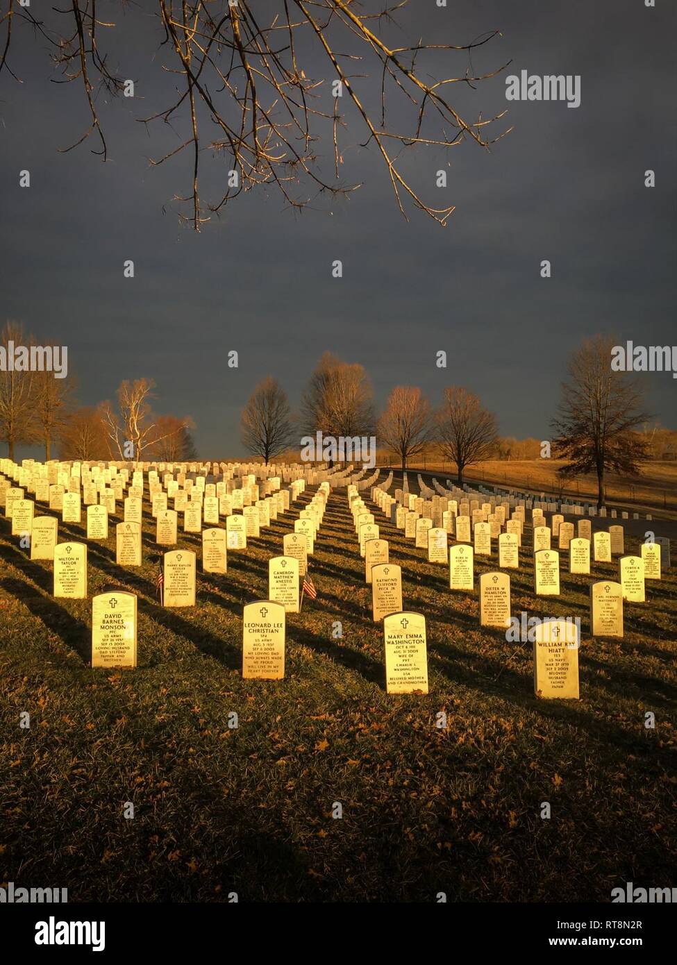 Raking light makes headstones glow like gold ingots at Camp Nelson National Cemetery near Nicholasville, Ky., Jan. 28, 2019. During the Civil War, Camp Nelson was home to a 700-bed Union Army hospital, numerous shops for blacksmith work and the construction of wagons and ambulances, artillery storage, and an enlistment station for African-American soldiers. The cemetery currently is home to thousands of U.S. military internments dating from the 1860s to the modern day, including veterans of the Kentucky Air National Guard. Stock Photo