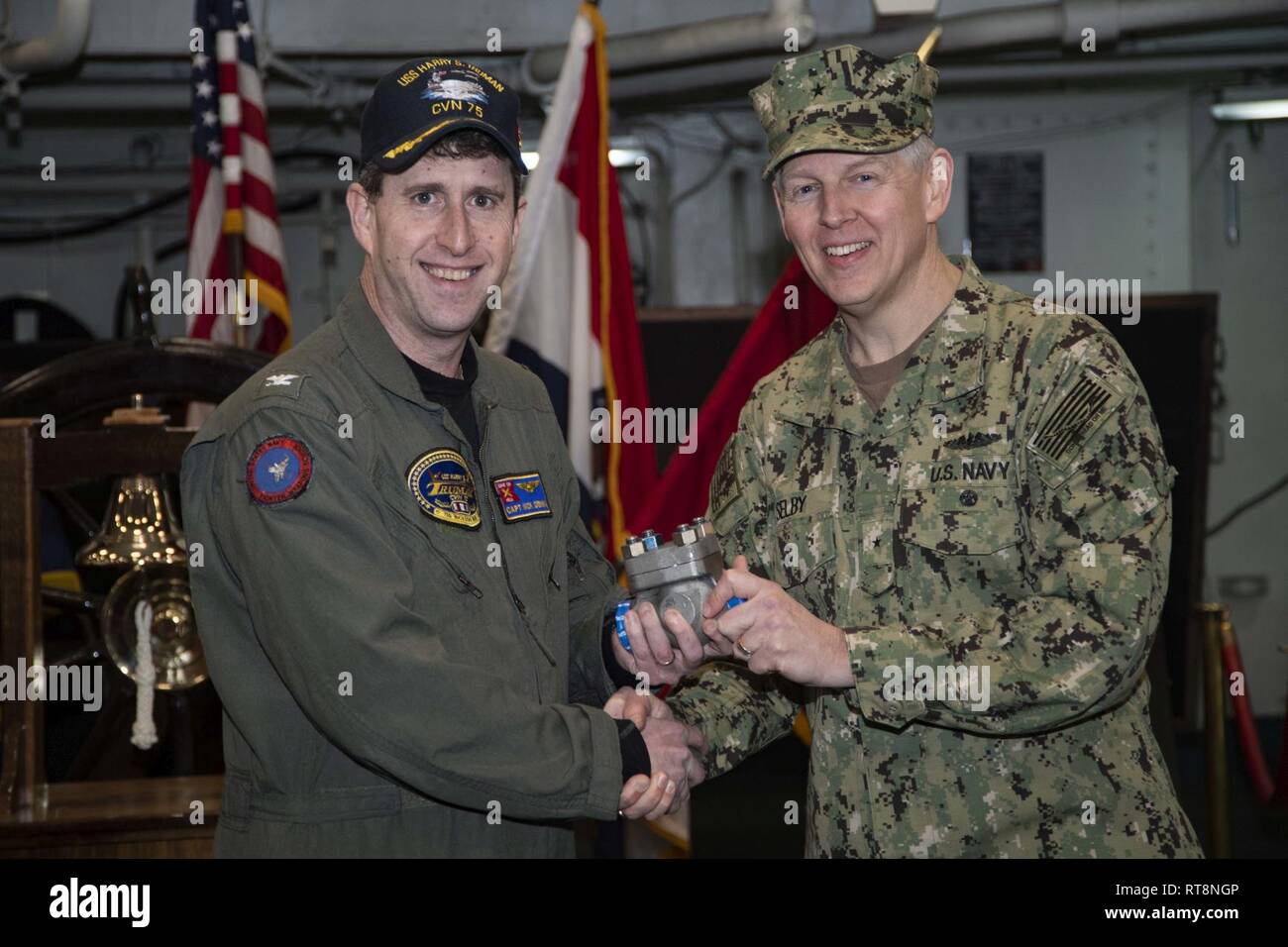 NORFOLK, Va. (Jan. 29, 2019) Naval Sea Systems Command Chief Engineer and Deputy Commander for Ship Design, Integration, and Naval Engineering, Rear Adm. Lorin Selby, right, presents USS Harry S. Truman (CVN 75) Commanding Officer, Capt. Nicholas Dienna, with the first 3-D printed metal part for installation and use on a U.S. Navy aircraft carrier. The piping assembly, manufactured by Huntington Ingalls Industries, will be installed and evaluated for a one-year period. Stock Photo