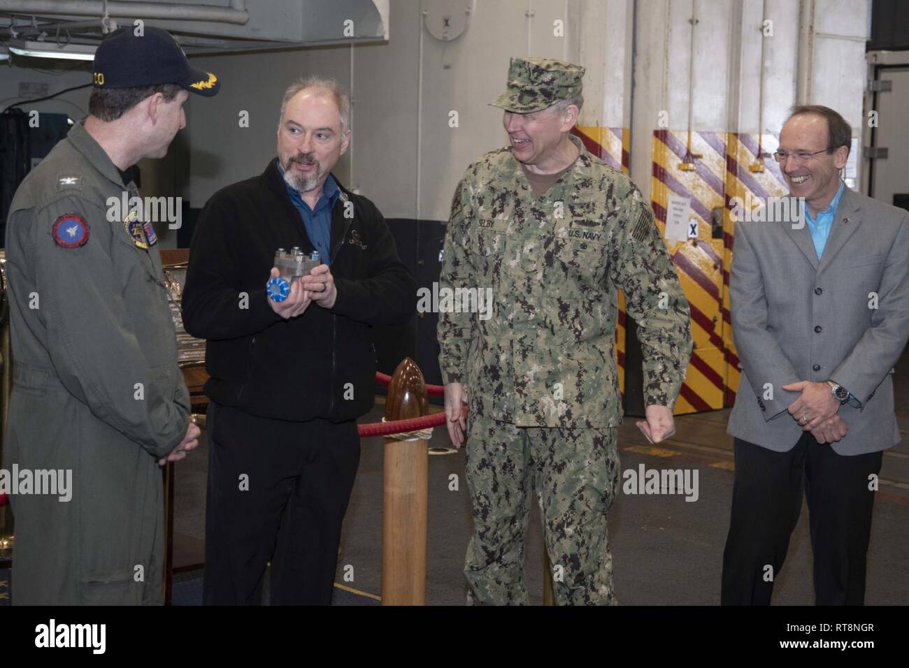 NORFOLK, Va. (Jan. 29, 2019) Mr. John Otis, the Maintenance Program Manager assigned to USS Harry S. Truman (CVN 75), discusses the first 3-D printed metal part for installation and use on a U.S. Navy aircraft carrier with Truman Commanding Officer, Capt. Nicholas Dienna, left, and Naval Sea Systems Command Chief Engineer and Deputy Commander for Ship Design, Integration, and Naval Engineering, Rear Adm. Lorin Selby, during a presentation ceremony aboard Truman. The piping assembly, manufactured by Huntington Ingalls Industries, will be installed and evaluated for a one-year period. Stock Photo