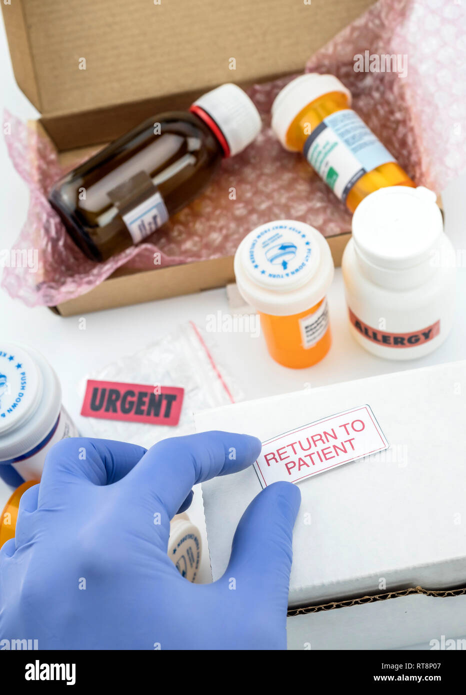 Nurse unpacking medication in boxes, pasting label return to the patient, conceptual image, composition vertical Stock Photo