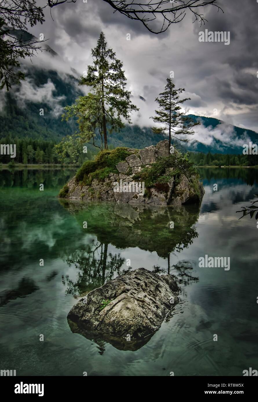mystic mountain lake with trees on rocks in green water, travel hinters Bavaria ramsau berchtesgaden Stock Photo
