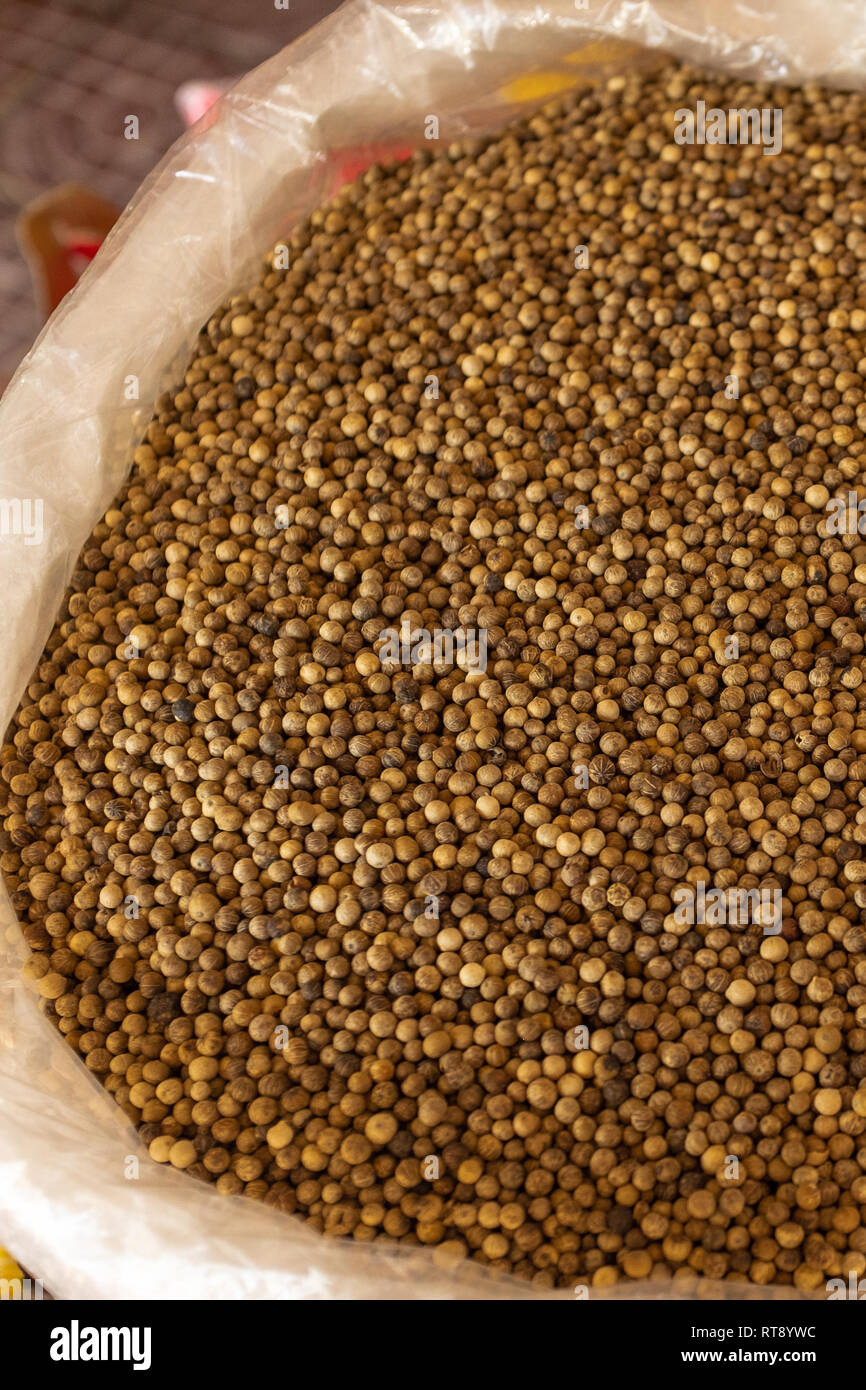 Close up of dried Kampot peppercorns for sale at a market, in a large