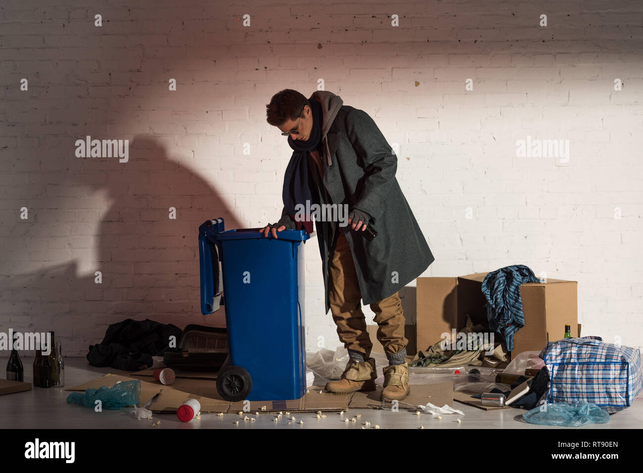 Poor man rummaging garbage in hi-res stock photography and images - Alamy