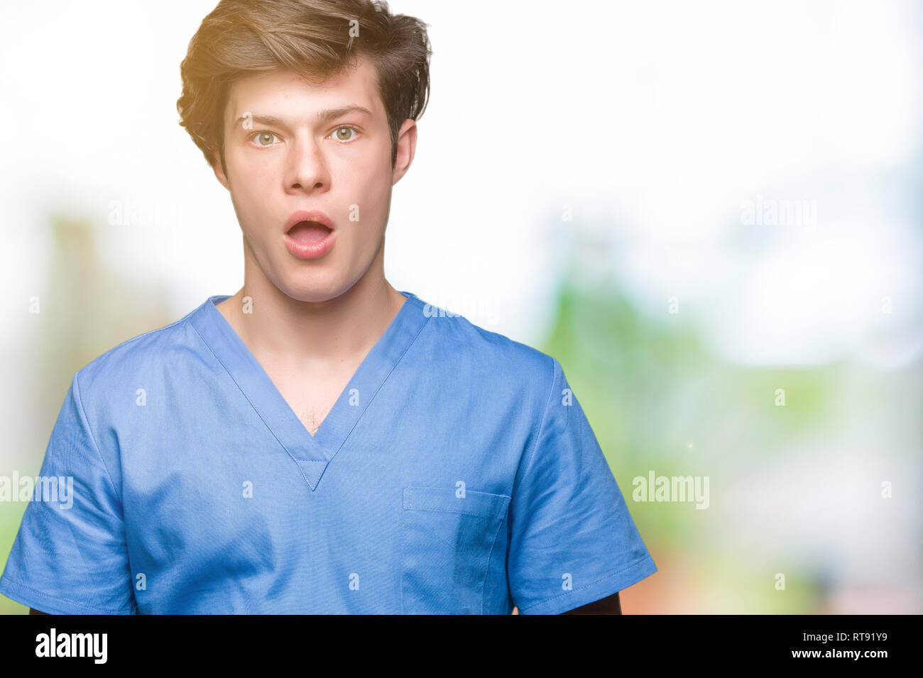 Young doctor wearing medical uniform over isolated background afraid ...