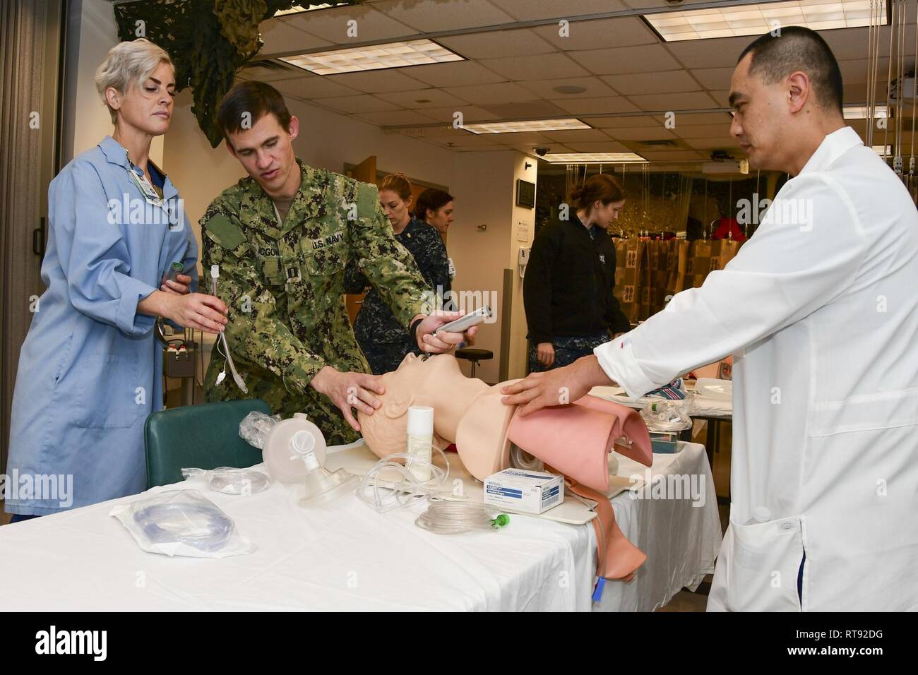 – Lt. Caitlin Brion, a staff nurse, receives hands-on training on how to intubate. Lt. Jonathan McGowen and Lt. Keenart Tio, Student Registered Nurse Anesthetists (SRNAs), conduct the training during the CRNA open house. Stock Photo