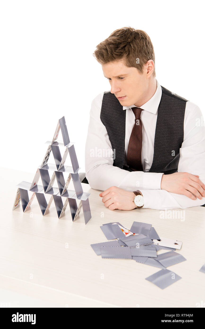 handsome concentrated manager making pyramid from playing cards isolated on white Stock Photo