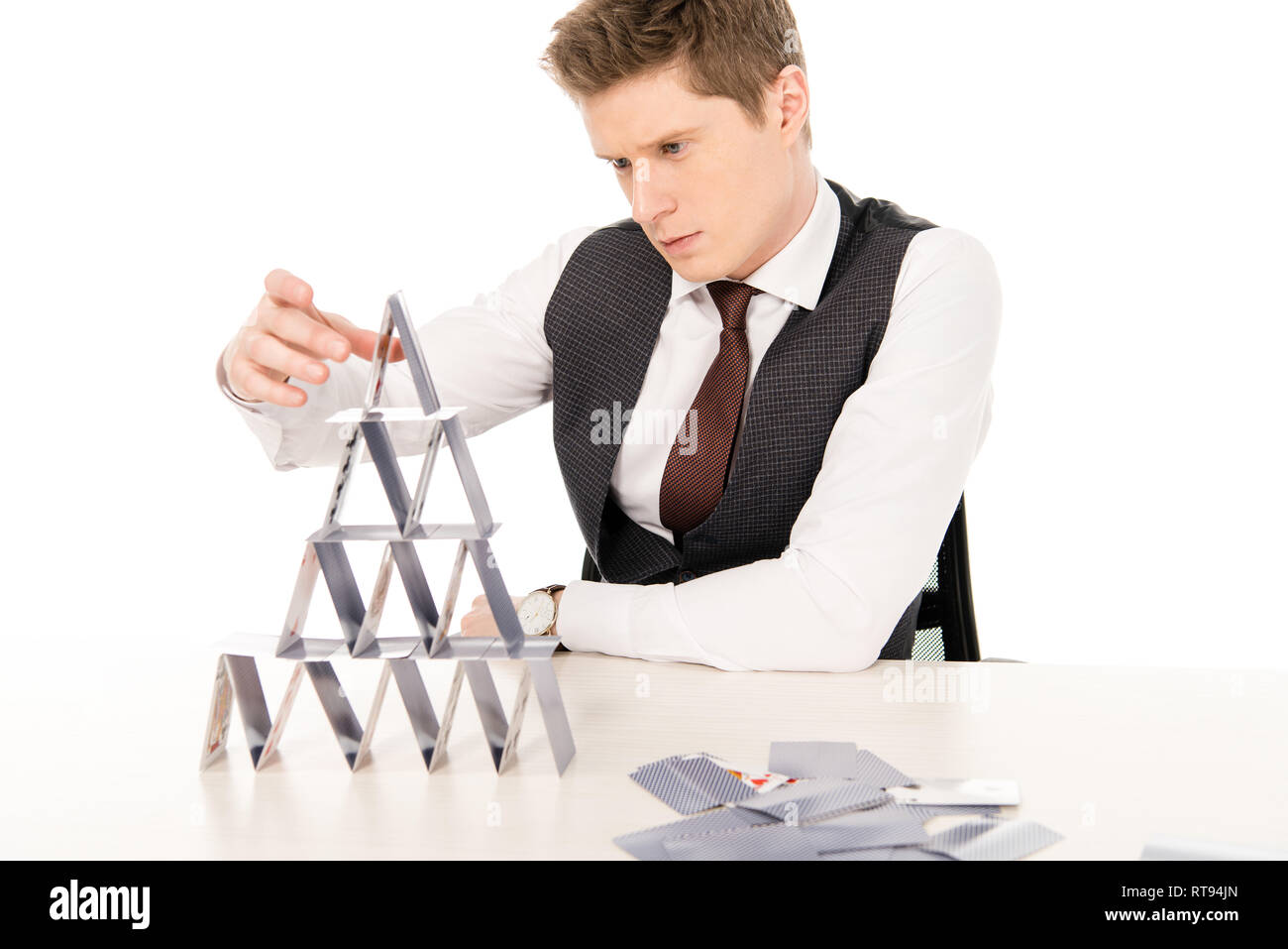 stylish man making pyramid from playing cards isolated on white Stock Photo