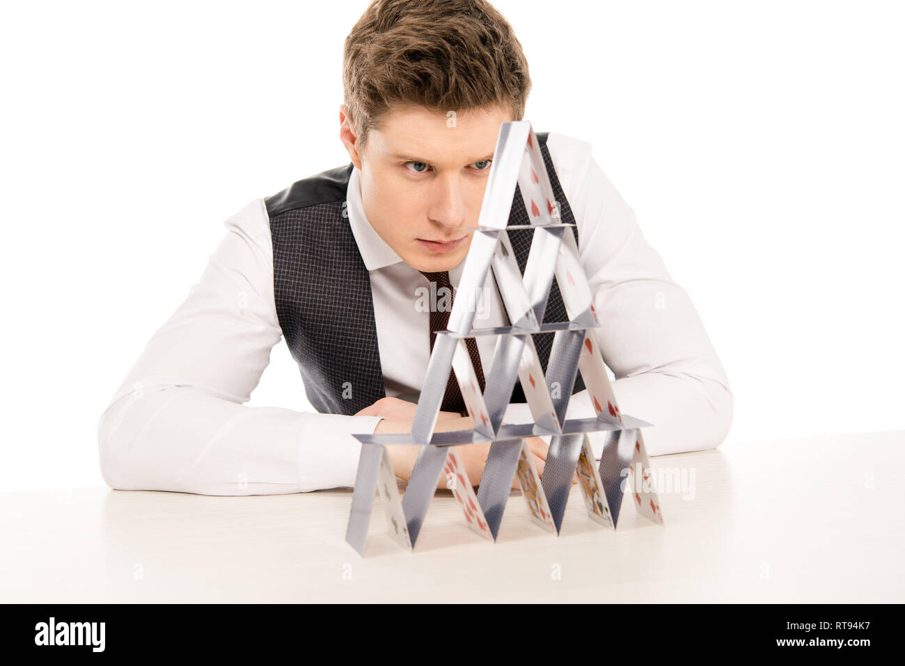 focused man making pyramid from playing cards isolated on white Stock Photo