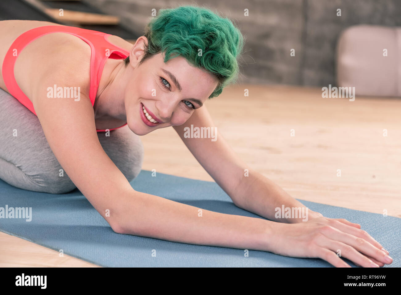 Fit beautiful woman doing her morning sport on blue mat Stock Photo