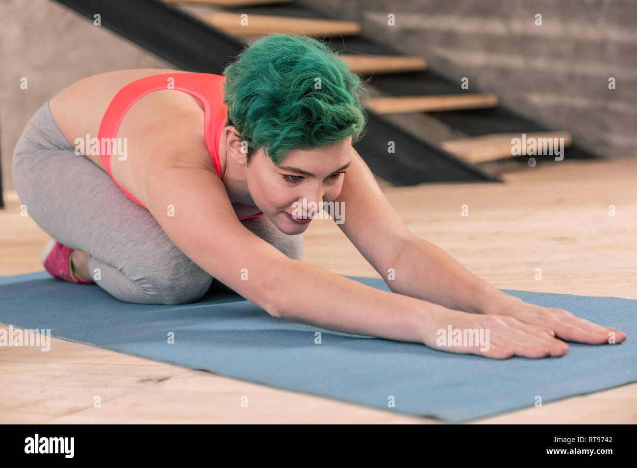 Beautiful green-haired woman attending fitness center after work Stock Photo