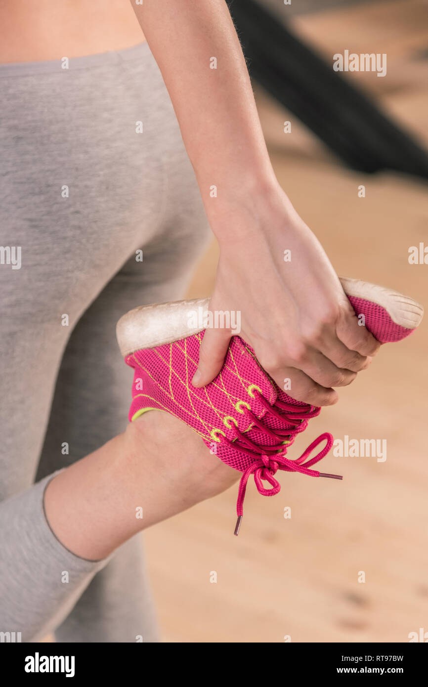 Woman wearing comfortable pink sneakers stretching legs Stock Photo