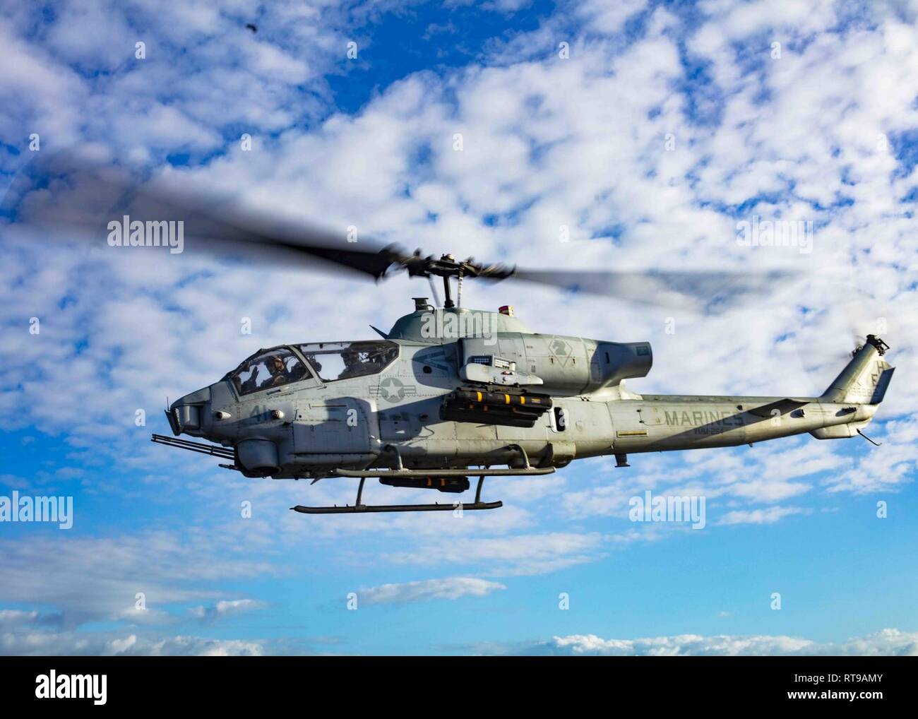 MEDITERRANEAN SEA (Jan. 30, 2019) An AH-1W Super Cobra helicopter assigned to the “Black Knights” of Marine Medium Tiltrotor Squadron (VMM) 264 (Reinforced) departs the flight deck of San Antonio-class amphibious transport dock ship USS Arlington (LPD 24), Jan. 30, 2019. Arlington is on a scheduled deployment as part of the Kearsarge Amphibious Ready Group in support of maritime security operations, crisis response and theater security cooperation, while also providing a forward naval presence. Stock Photo