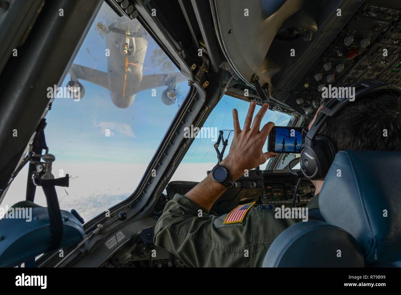 Capt. Ryan Arsenault, 7th Airlift Squadron (AS) pilot, documents training while Maj. Gene Ballou, 313th AS pilot, prepares to refuel from a KC-46 Pegasus. Over 170 KC-46s are planned to replace aging tankers and revitalize the Air Force tanker fleet. Stock Photo