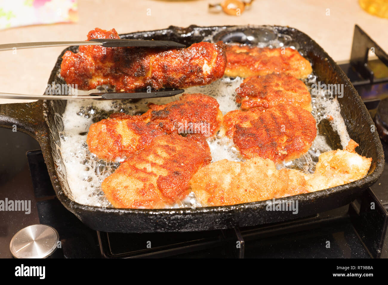 cooking nuggets from fresh chicken meat on a hot cast-iron pan Stock Photo