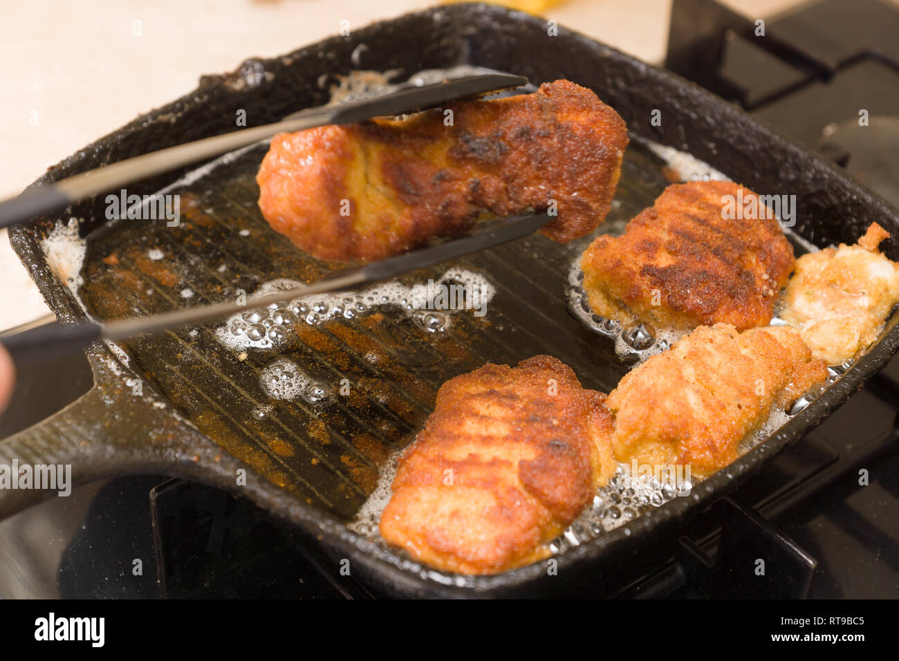 cooking nuggets from fresh chicken meat on a hot cast-iron pan Stock Photo