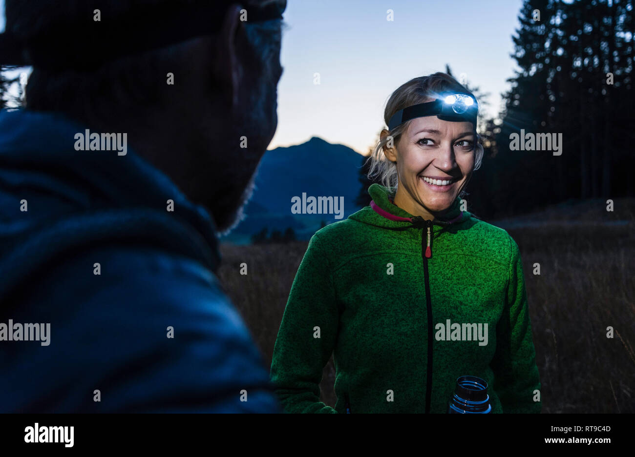 Couple hiking at night, wearing head lamps Stock Photo