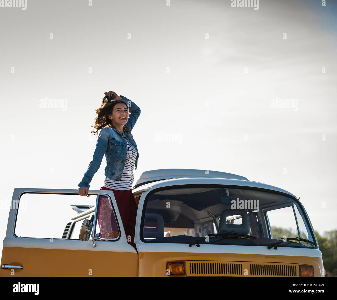 Pretty woman on a road trip with her camper, cheering, enjoying freedom ...