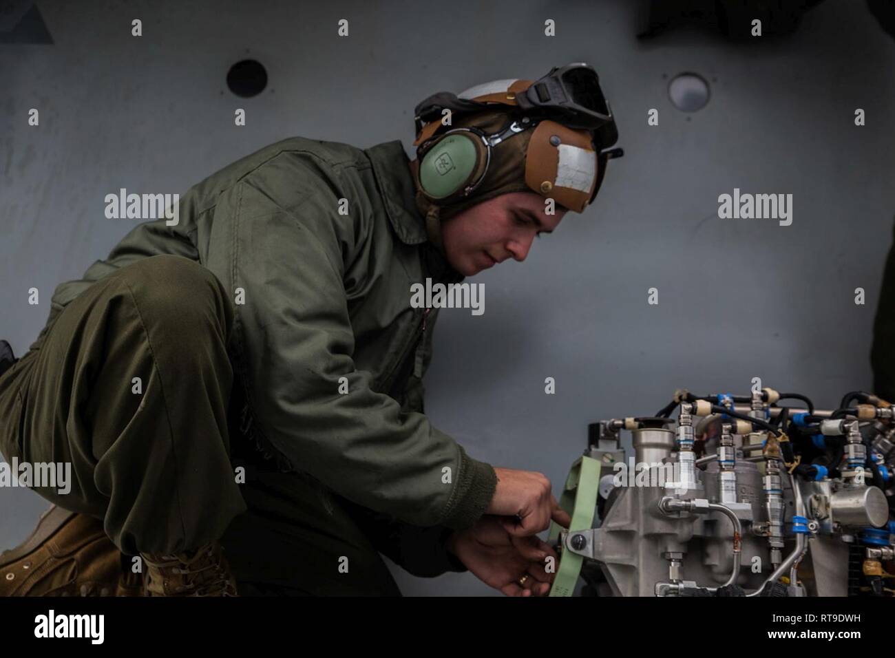 Sgt. Riley D. Schroer, a tiltrotor mechanic with Marine Medium Tiltrotor Squadron 262 (Reinforced), prepares an auxiliary power unit for installation onto an MV-22B Osprey tiltrotor aircraft atop the flight deck aboard the amphibious assault ship USS Wasp (LHD 1), Philippine Sea, Jan. 27, 2019. Schroer, a native of Liberty, Missouri, graduated from Liberty High School in May 2013 before enlisting in July the same year. VMM-262 (Rein.) is the Aviation Combat Element for the 31st Marine Expeditionary Unit. VMM-262 (Rein.) maintainers ensure the squadron’s aircraft are safe for flight during flig Stock Photo