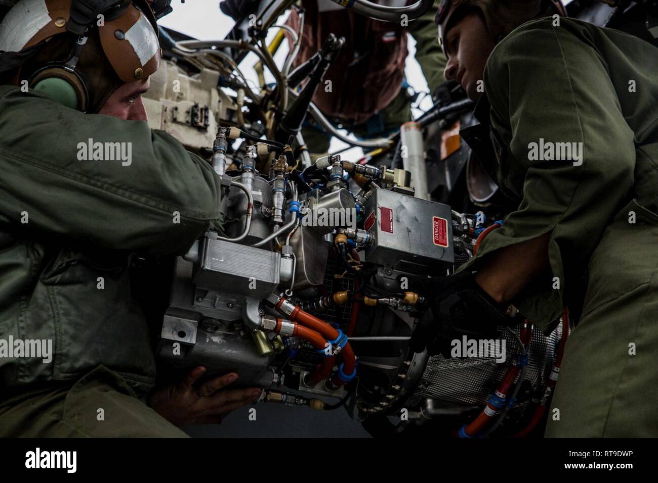 Marines with Marine Medium Tiltrotor Squadron 262 (Reinforced) install an auxiliary power unit onto an MV-22B Osprey tiltrotor aircraft atop the flight deck aboard the amphibious assault ship USS Wasp (LHD 1), Philippine Sea, Jan. 27, 2019. VMM-262 (Rein.) is the Aviation Combat Element for the 31st Marine Expeditionary Unit. VMM-262 (Rein.) maintainers ensure the squadron’s aircraft are safe for flight during flight operations. The 31st MEU, the Marine Corps’ only continuously forward-deployed MEU partnering with the Wasp Amphibious Ready Group, provides a flexible and lethal force ready to p Stock Photo