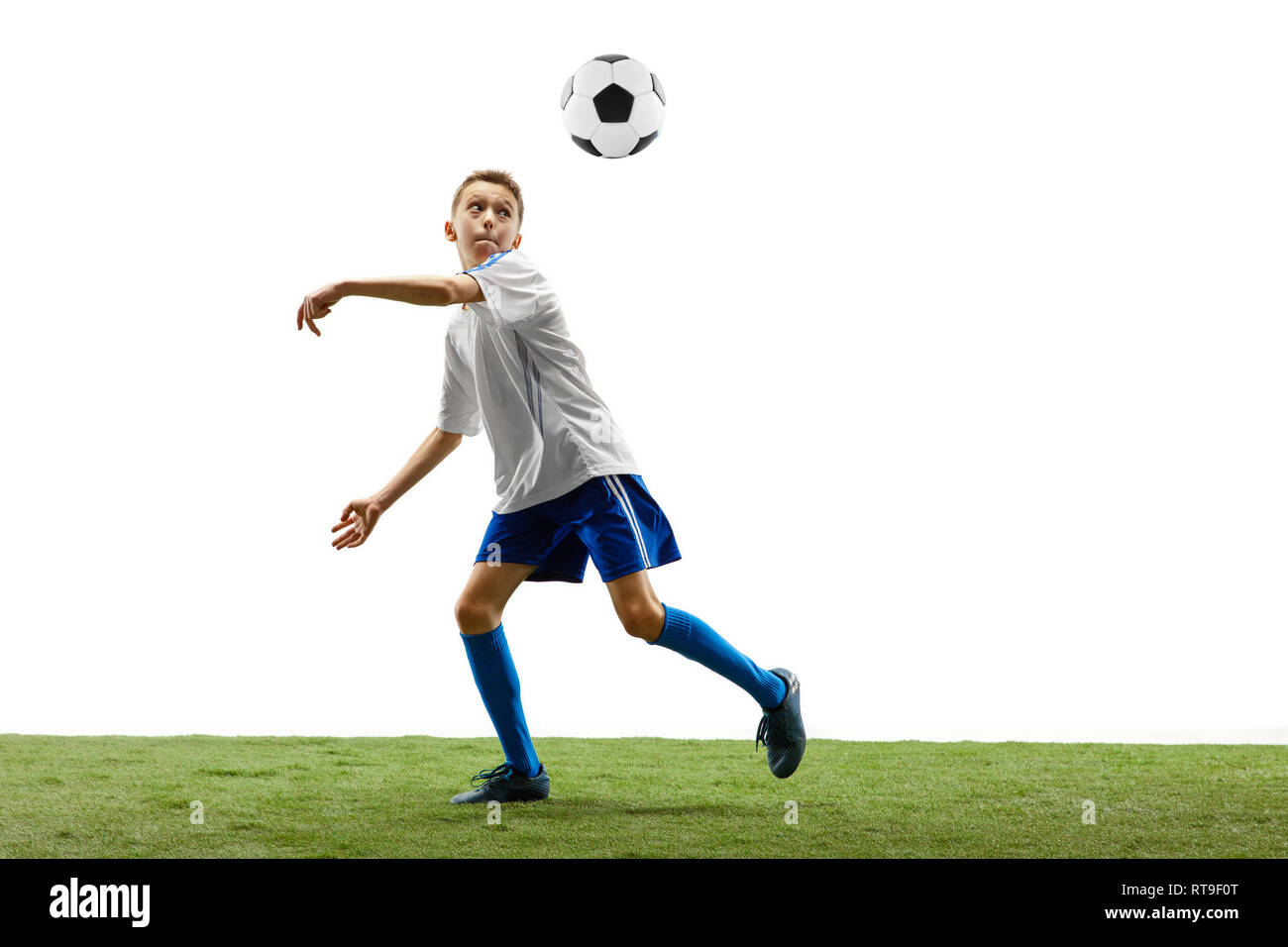 Young boy with soccer ball running and jumping isolated on white