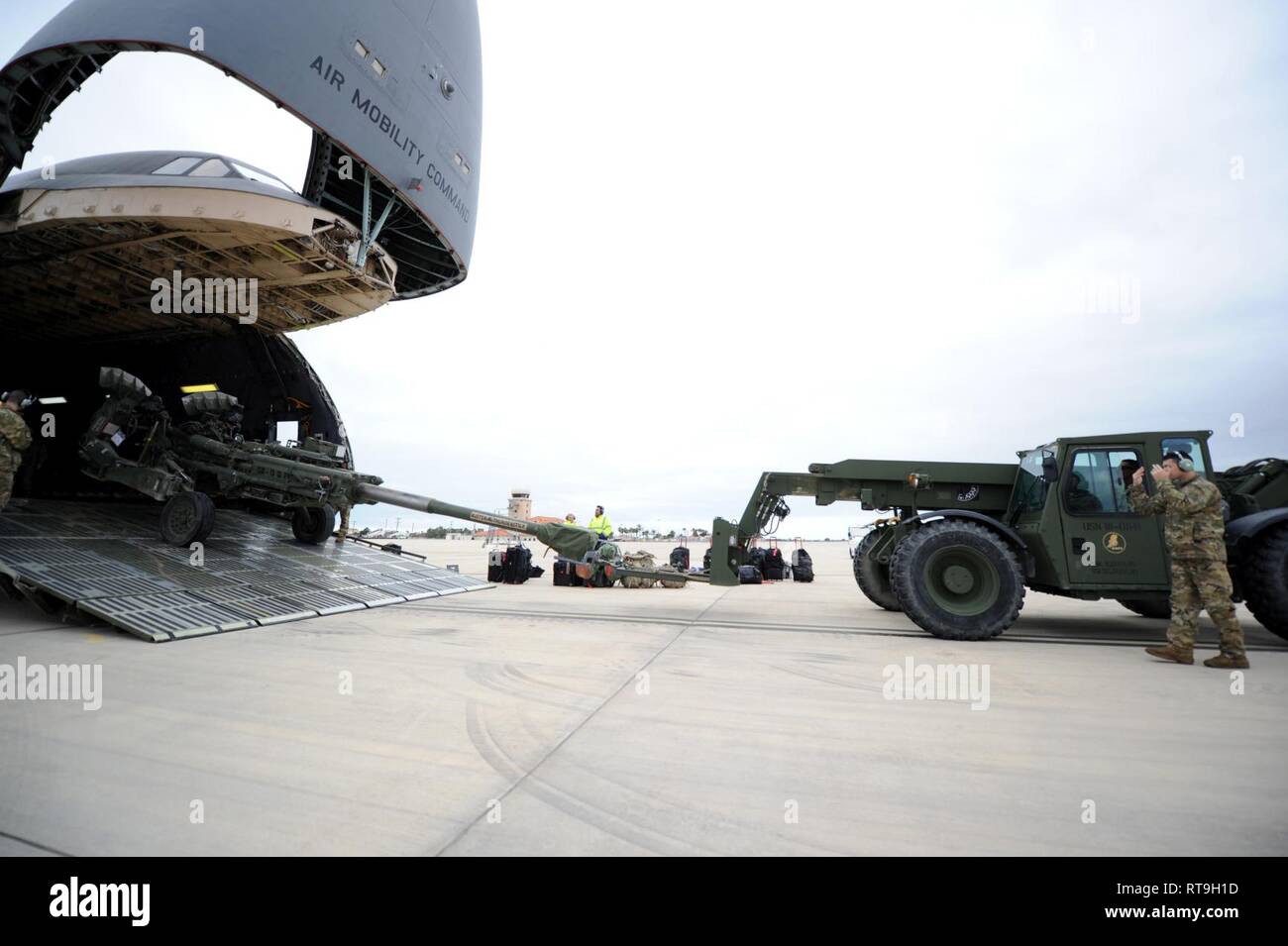 NAVAL STATION ROTA, Spain (Jan. 29, 2019) Seabees assigned to Naval Mobile Construction Battalion (NMCB) 1 and U.S. Air Force (USAF) airmen assigned to the 22nd Airlift Squadron download U.S. Army M777 howitzers from a USAF C5M Super Galaxy during an embarkation operation. NMCB-1 is forward deployed to execute construction, humanitarian and foreign assistance, and theater security cooperation in the U.S. 6th Fleet area of operations. Stock Photo