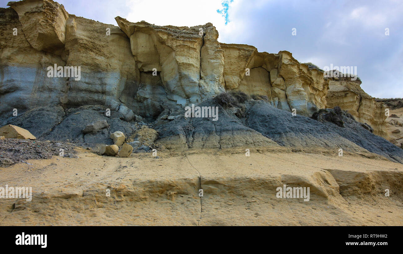 An eroded cliff face near the sea on the Mediterranean island of Malta. Layers of rock stratification can be seen. A perfect place for fossils/ Stock Photo