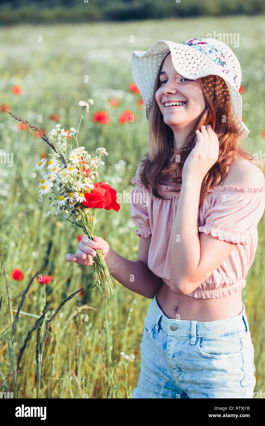 Beautieful young girl in the field of wild flowers. Teenage girl ...