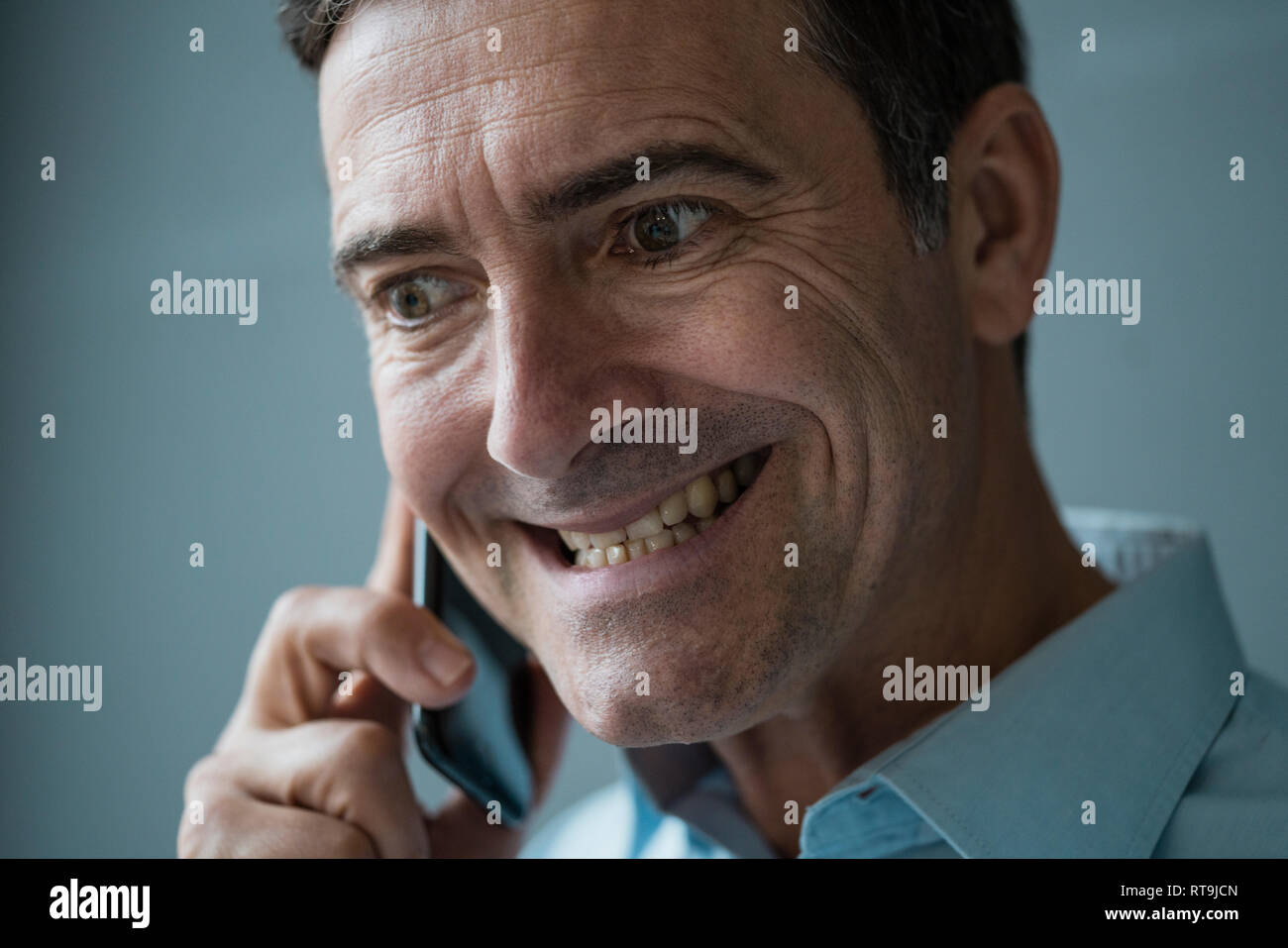 Portrait of grimacing businessman on cell phone Stock Photo