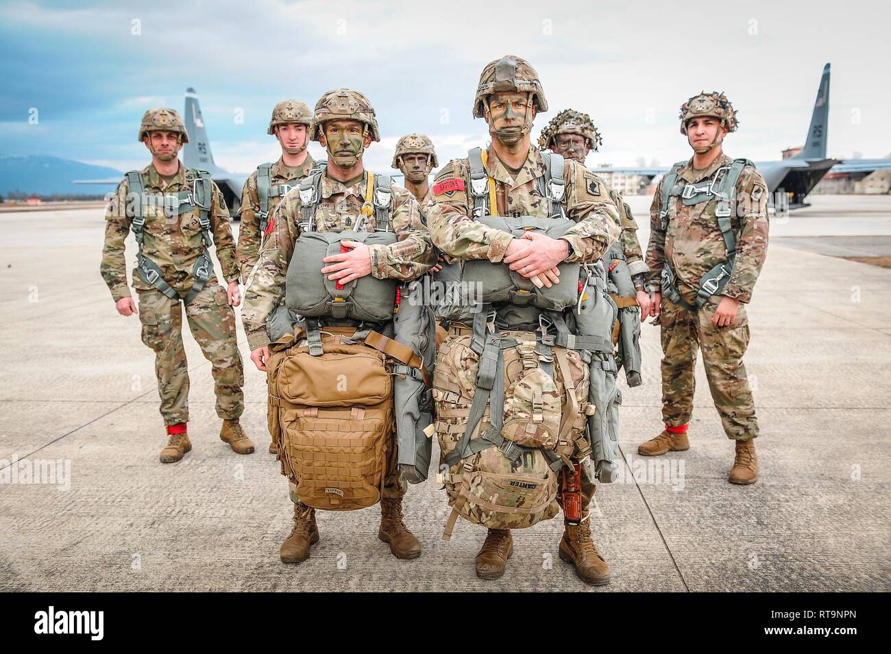 First Sergeant Glenn Taylor (left) and Captain Jesse Carter (right), the command team of Bravo Company, 54th Brigade Engineer Battalion, 173r Airborne Brigade, stand proudly with their fellow jumpmasters before conducting an airborne operation on January 31, 2019. Stock Photo