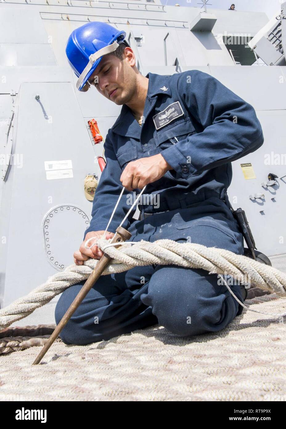 SINGAPORE (Jan. 31, 2019) Boatswain’s Mate 3rd Class Ivan Naranjo, from Chicago, repairs a mooring line on the forecastle aboard the San Antonio-class amphibious transport dock ship USS Anchorage (LPD 23) while on a deployment of the Essex Amphibious Ready Group (ARG) and 13th Marine Expeditionary Unit (MEU). The Essex ARG/13th MEU is a capable and lethal Navy-Marine Corps team deployed to the 7th fleet area of operations to support regional stability, reassure partners and allies and maintain a presence postured to respond to any crisis ranging from humanitarian assistance to contingency oper Stock Photo