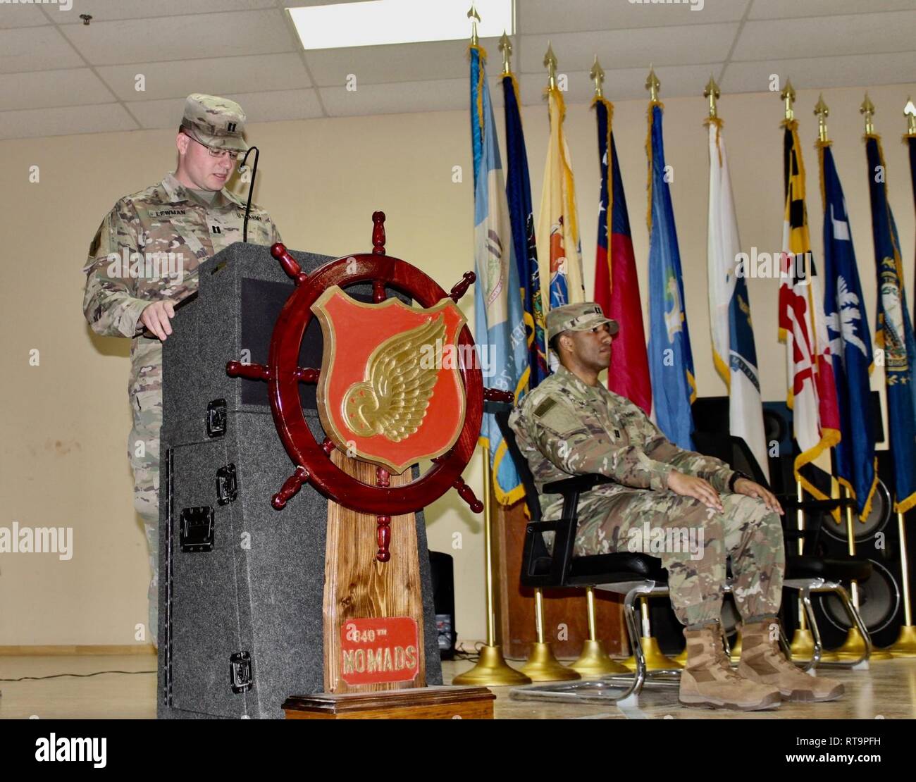 Capt. Willard C. Lewman makes his exiting remarks as company commander of Headquarters and Headquarters Detachment, 840th Transportation Battalion, as Capt Michael D. McDonald, the incoming commander, awaits to assume command during a change of command ceremony at Camp Arifjan, Kuwait, Jan. 31, 2019. Stock Photo