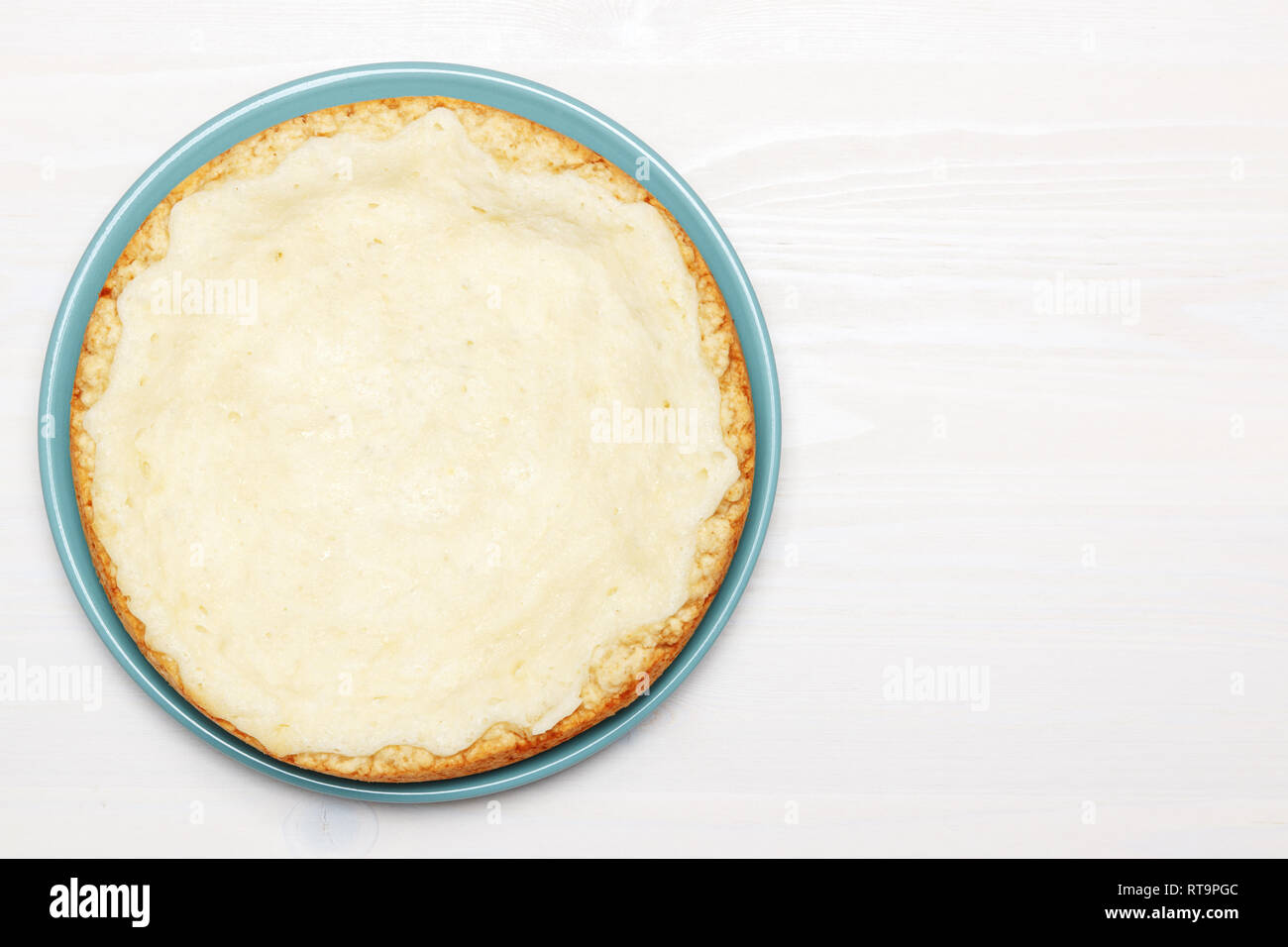 Whole cheesecake on a wooden white table. Top view. Copy space Stock Photo