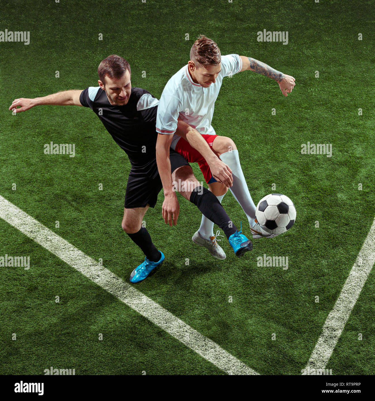 Football player tackling for ball over green grass background ...