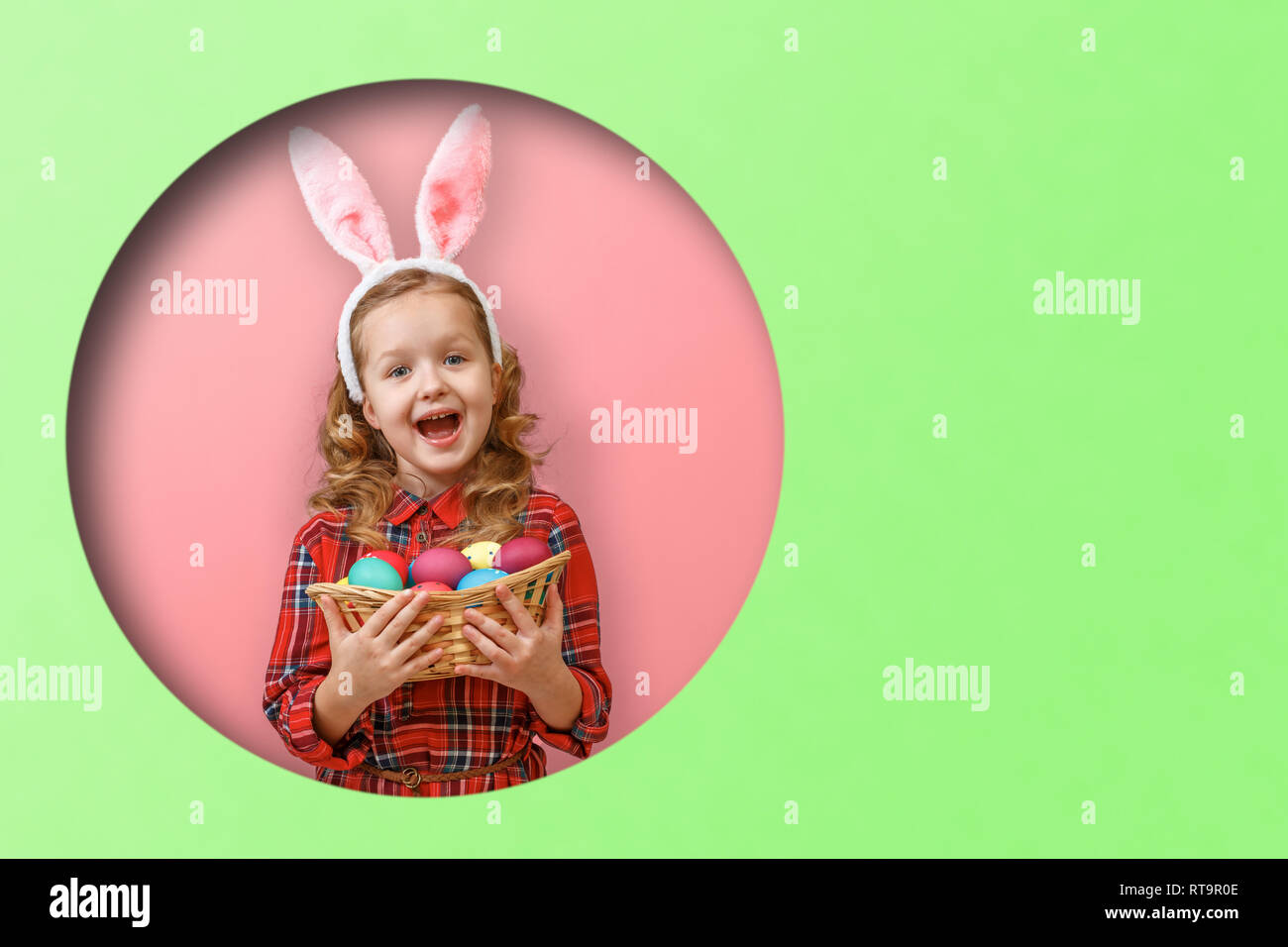 Cute little girl with bunny ears holding basket of Easter eggs. Kid in ...