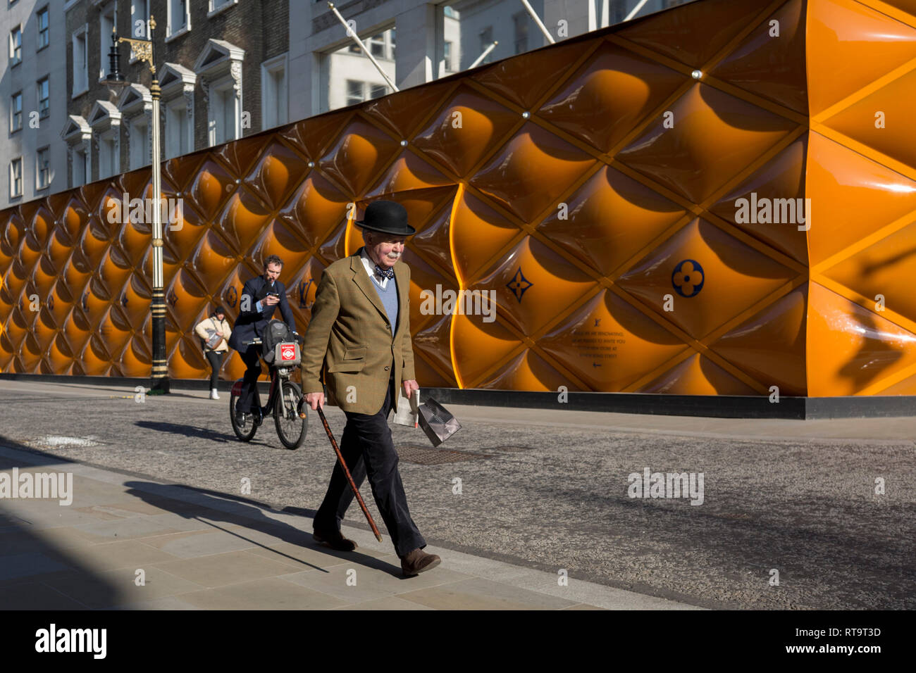 A classically-dressed English gentleman walks the temporary renovation hoarding of luxury brand Louis Vuitton in New Bond Street, on 27th February 2019, in London, England Stock Photo - Alamy