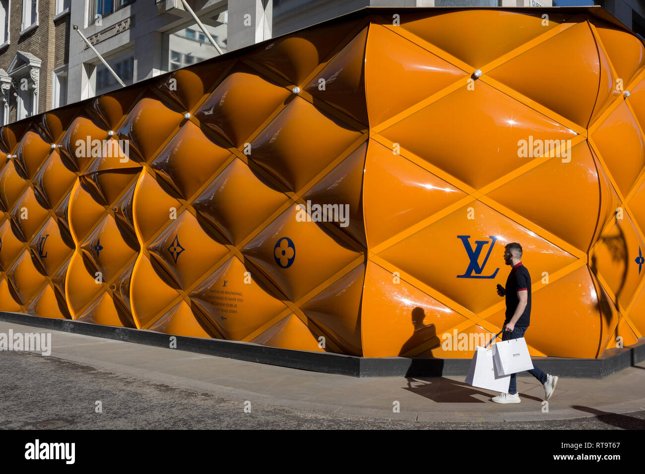 A shopper passes-by the temporary renovation hoarding of luxury brand Louis  Vuitton in New Bond Street, on 25th February 2019, in London, England Stock  Photo - Alamy